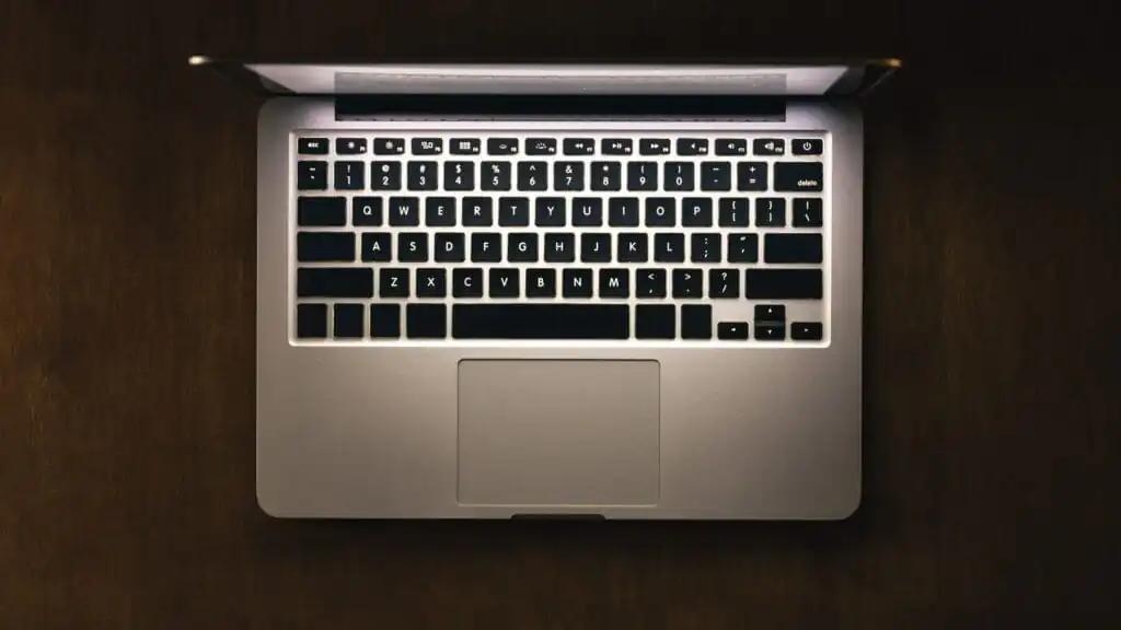 Top view of a laptop on a dark table, glowing screen.