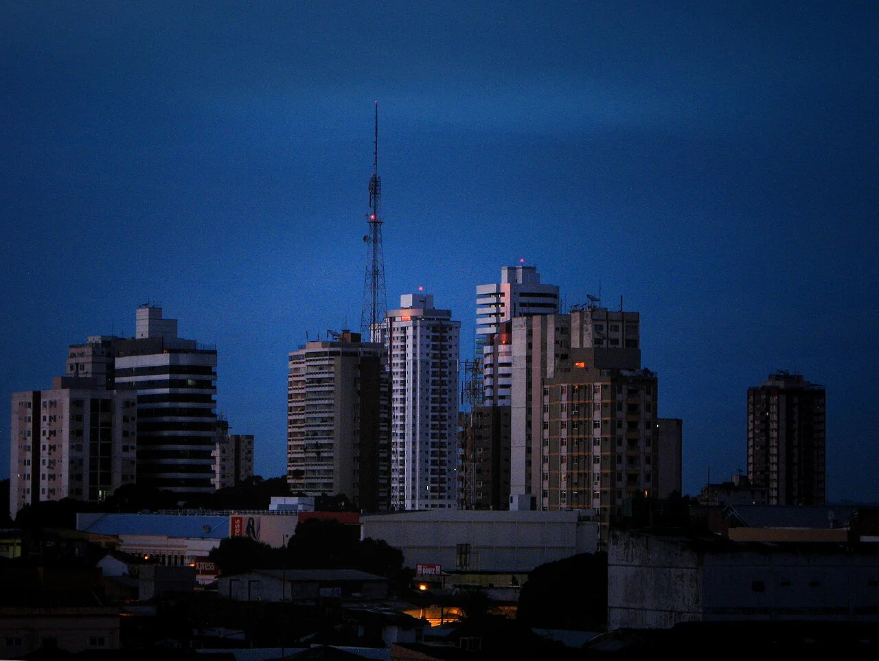 Prédios do centro de Belém ao anoitecer, com uma torre de antena ao fundo