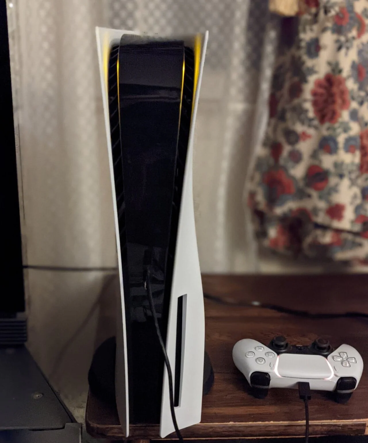 Console PlayStation 5 em pé ao lado do controle DualSense